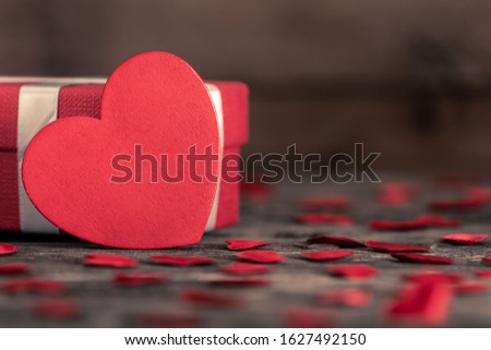 Valentine's day greeting card for love with red heart shape and gift box on wooden background