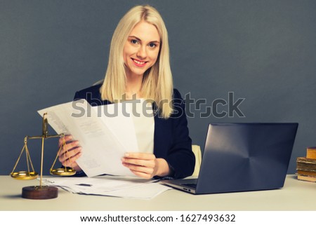 Portrait of smiling businesswoman looking at camera and smiling while working at office - image toned