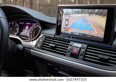 Interior of premium car with rearview camera dynamic trajectory turning lines and parking assistant. Driver assistance system for parking. Help assist options inside luxury car Royalty-Free Stock Photo #1627497103
