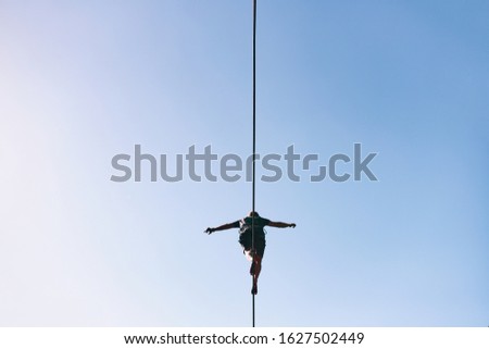 Young Caucasian slackline man practicing slackline against the sky on a clear summer day Royalty-Free Stock Photo #1627502449
