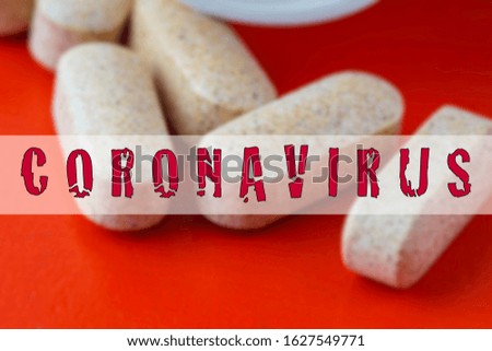 Coronavirus wording over the blurry pills on the red background. Coronaviruses are a group of viruses that cause diseases in mammals, including humans, and birds.