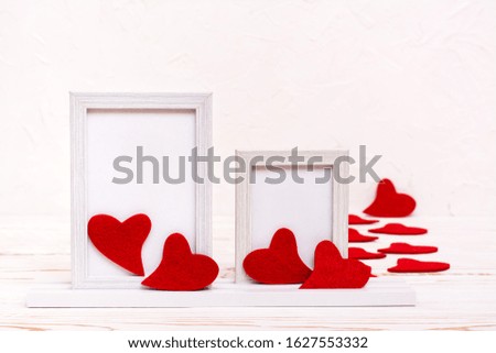 Valentine's Day. Ready Mock up. Two empty white frames surrounded by red felt hearts on a white background. Copy space