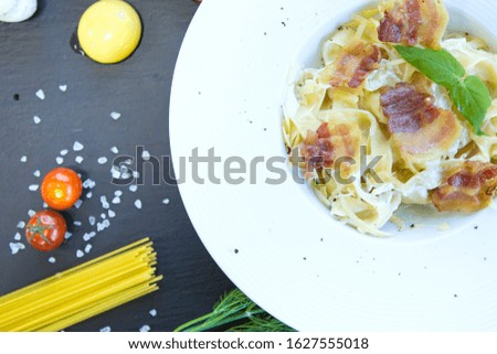 Pasta with bacon on black stone surface Healthy and tasty food.
