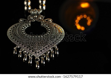 beautifull indian german silver jewellry for indian wedding ceremony placed on a dark base. The yellow boque effect is adding majesty to the product.