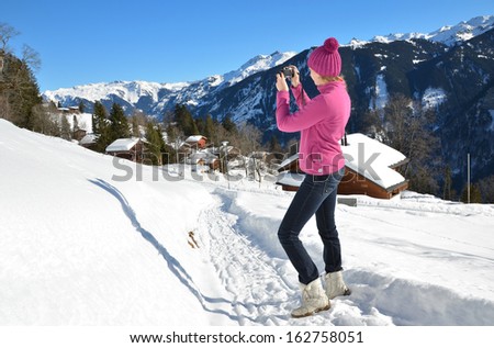 Girl taking a photo in the Swiss Alps 