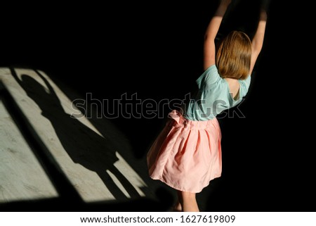 girl in beautiful and delicate clothes dancing. dance ballerina in a pink skirt. Game with a shadow. silhouette of a little princess