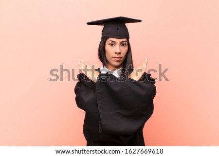 young latin woman student looking annoyed and sick of your attitude, saying enough! hands crossed up front, telling you to stop