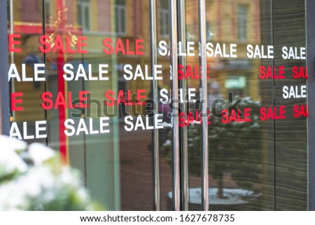 The inscription sale on the glass doors to the fashion boutique store.