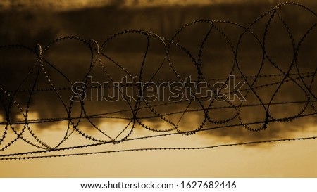 Silhouette of barbed wire fence during sunset time.                   