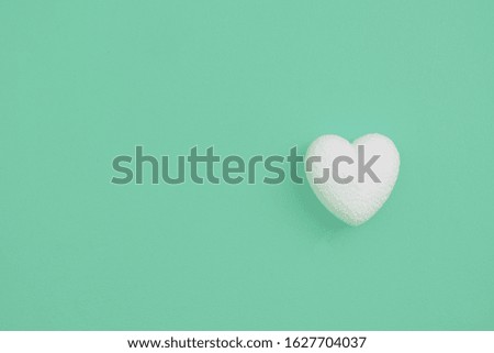 White heart on a pastel green background