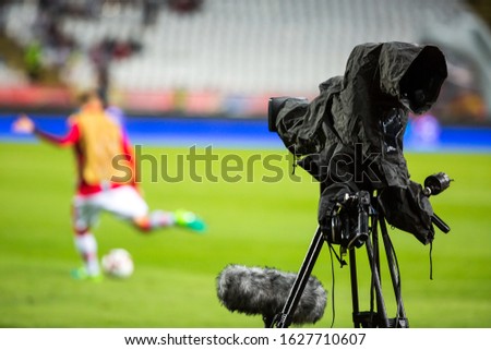 TV camera at the stadium, broadcasting during a football (soccer) match