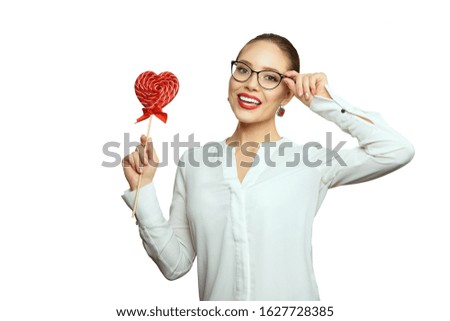 Beauty girl with a red lollipop in shape love heart, isolated on a white background. Beautiful Happy Young woman presenting products. Valentine day