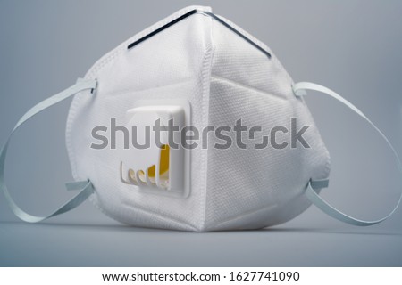 White n95 mask on blue background, n95 respirator with ventilation valve, anti-haze mask,