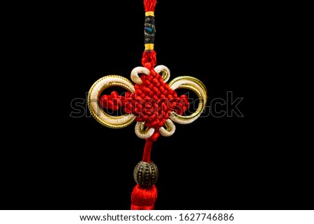 Chinese knotting with red braid on a black background