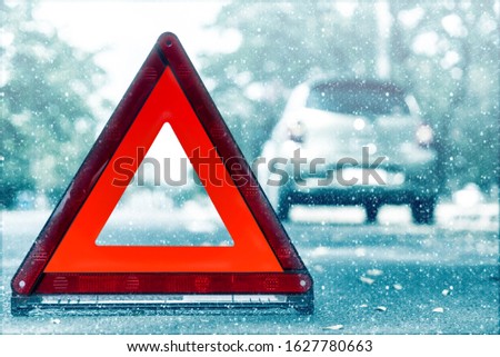 Snow time black car have accident park on road. Red triangle, red emergency stop sign, red emergency symbol and black car stop and park on road.