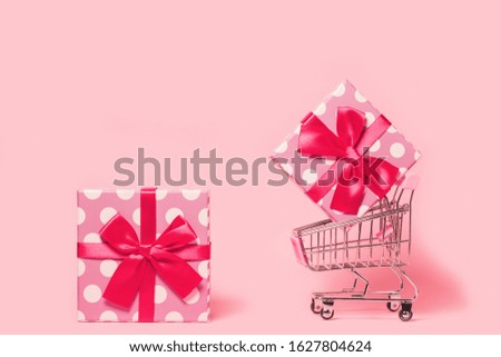 Small decorative trolley with present boxes on bright colorful background. Christmas or birthday gift. Sales and shopping concept.  Image is with copy space