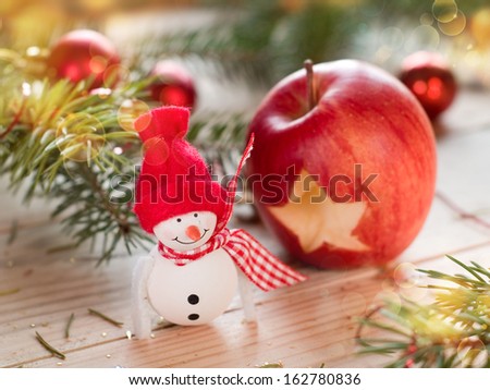 Snowman with apple on holiday background, selective focus