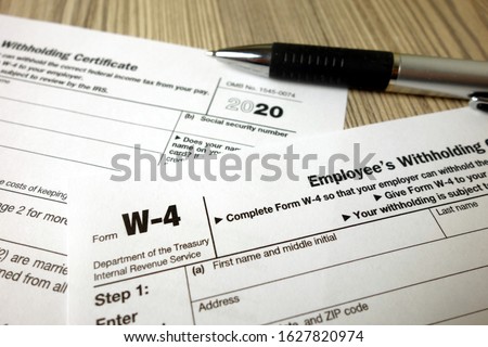 Blank W-4 tax form and a pen. Tax season Royalty-Free Stock Photo #1627820974