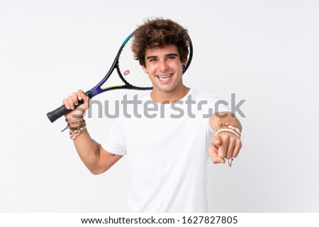 Young caucasian man over isolated white background playing tennis and pointing to the front