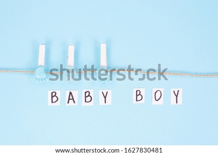 Invitation for shower party concept. Top view photo of background with clothespins and inscription baby boy on it