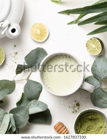 Cup of  Organic Green Matcha Tea on white background and eucalyptus branch. Flat lay, top view