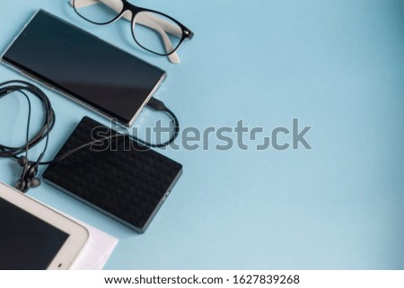 A light blue table with the necessary items on it. Diary with pen, phone. White cup of coffee. Top view with copy space,