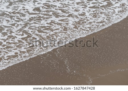 Photography of oceanic shore. Soft surf, waves and water surface. Natural background. Concepts of beauty in nature and tourism and touristic time.