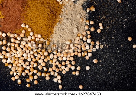 
A variety of spices, beans and corn on a black background,with empty space for text or label. Menu design. Spices close-up.