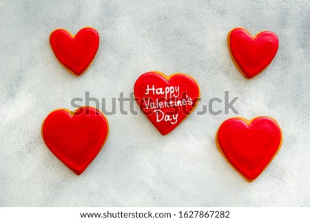 Valentine's Day. Gingerbread cookies in the shape of a red and white heart, 
with the image of a couple in love and a love letter. Gray marble background top view,flat lay, mockup