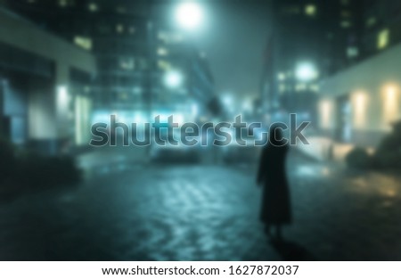 Mysterious figure standing on foggy street at night, blurred.