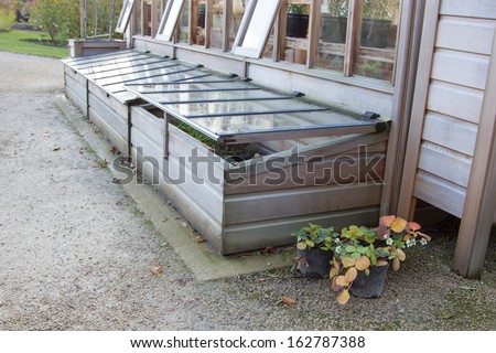 cold frames against greenhouse and strawberry plants in pots Royalty-Free Stock Photo #162787388
