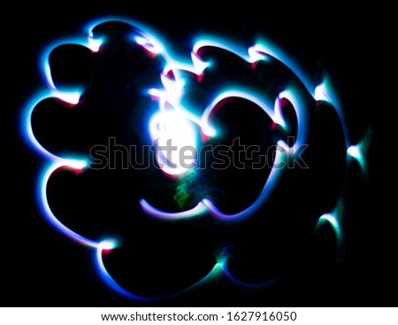 Abstract, colored light streaks and patterns on a black background