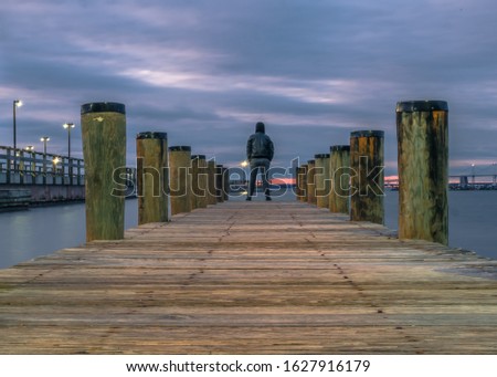 Standing up at the edge of the pier