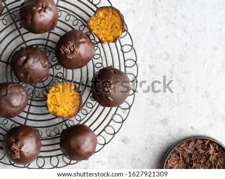 Carrot energy balls (bliss balls), healthy sugar free candies covered by dark chocolate, decorated with chocolate shred. Top view. Vegetarian snack, food for health. Royalty-Free Stock Photo #1627921309