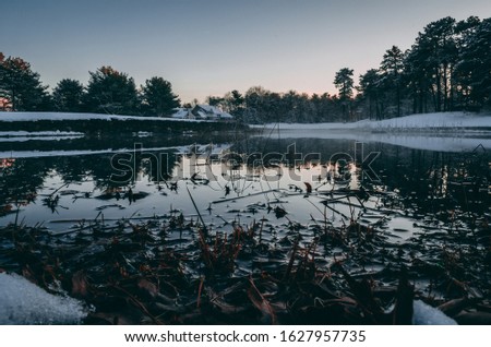 reflection of snowy background onto glass pond