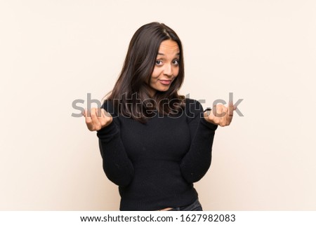 Young brunette woman with white sweater over isolated background making money gesture