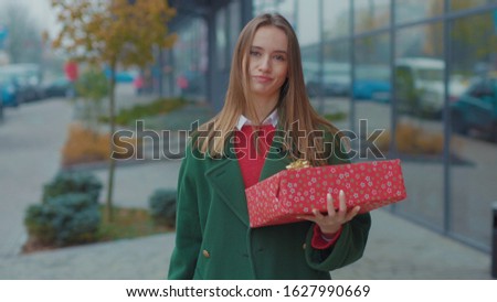 Portrait beautiful young woman hold Christmas presents not satisfied with the gift boxes look around outdoors store winter girl christmas time holiday shop package attractive slow motion