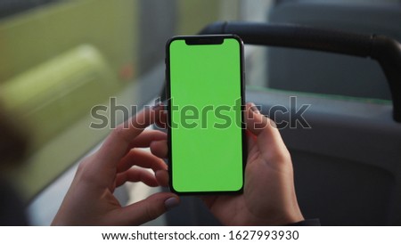 Lviv, Ukraine - May 19, 2018: Hands use touch holding a mobile telephone with a vertical green screen in tram chroma key smartphone technology cell phone street touch message display hand