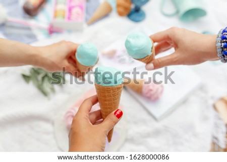 Girl holds a menthol ice cream cone in her hand.