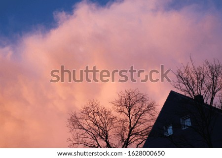 Blue sky, pale pink clouds and triangular roof
