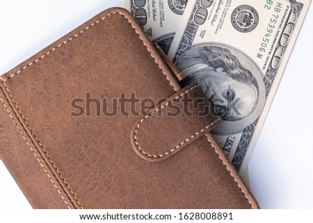 A leather wallet and dollars on white background close up as a symbol of wealth and financial prosperity, earning money and richness.