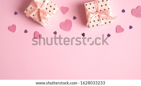 Valentine's day frame border of gifts and heart shaped decorations on pink background. Flat lay, top view. Creative design for party invitation, banner, greeting card. Love and romance concept.