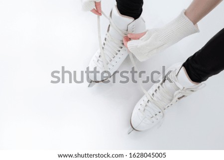 Closeup of Teenager Girl hands Lacing Up Iceskates. Horizontal Image