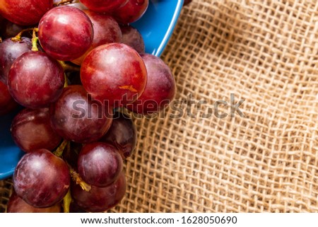 
fresh grapes on plate and wooden table