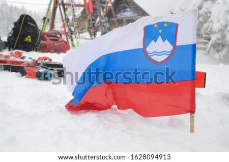Slovenian flag waving on the heavy wind. Slovenian national flag flying in the snow on the mountain. Flag blowing in the wind