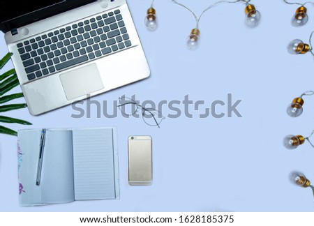 flat lay of laptop and notebook on light blue background