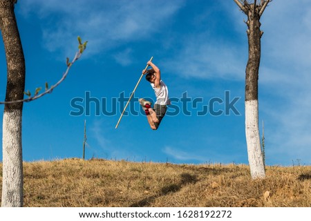 Man jumping with kung-fu staff