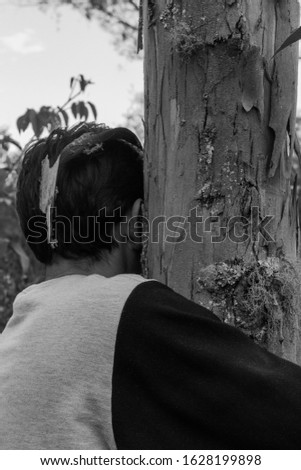 Person hugging a tree trunk