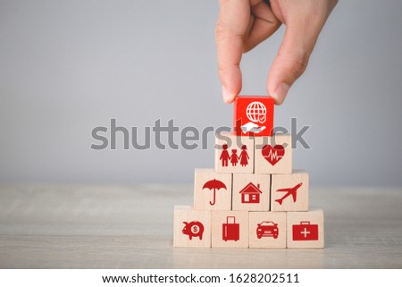 Hand arranging wood block stacking with icon insurance: car,
