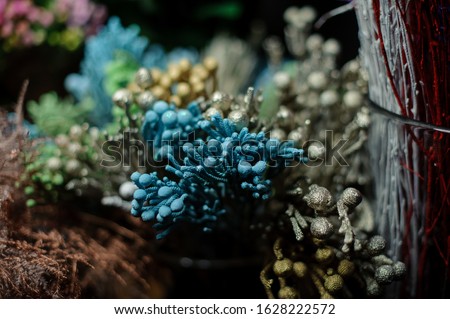 Bouquet of blue, freen golden and siver decoration in the blurred background of the flower shop